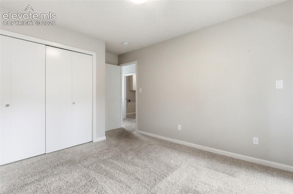Image 40 of 50: Neutral-toned walls complement the light gray carpeting
