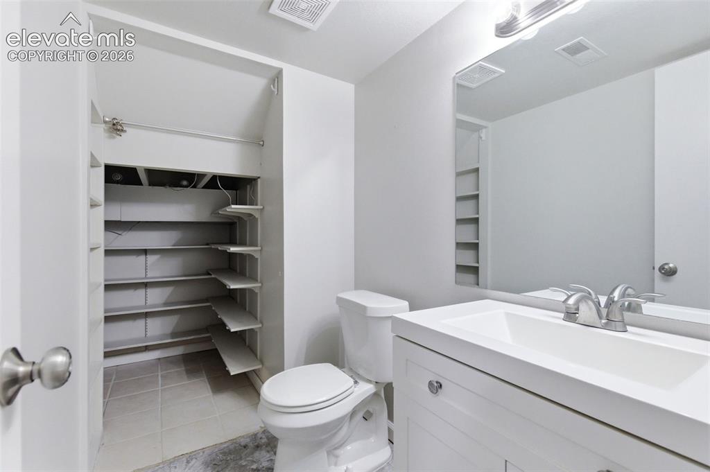 Image 6 of 50: Bathroom featuring a white vanity with integrated sink, chrome faucet, and