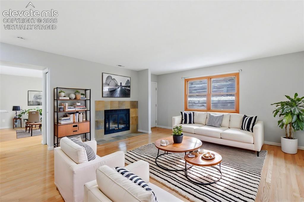 Image 9 of 50: Virtually Staged
Living area featuring wood-finish flooring, a stone-sur