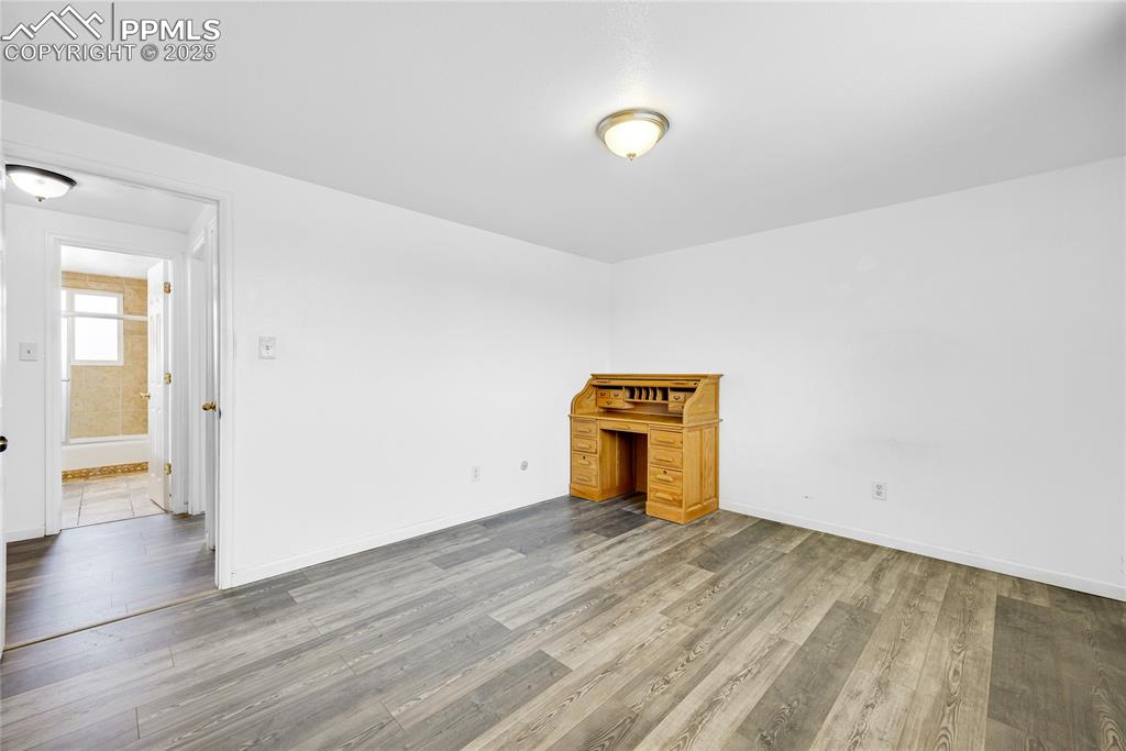 Image 13 of 24: Spare room with wood finished floors and baseboards