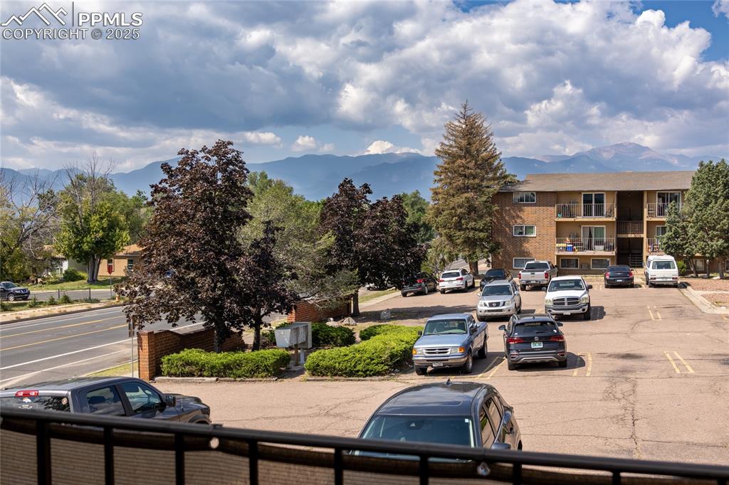 Image 22 of 24: View of building exterior with a mountain view and uncovered parking