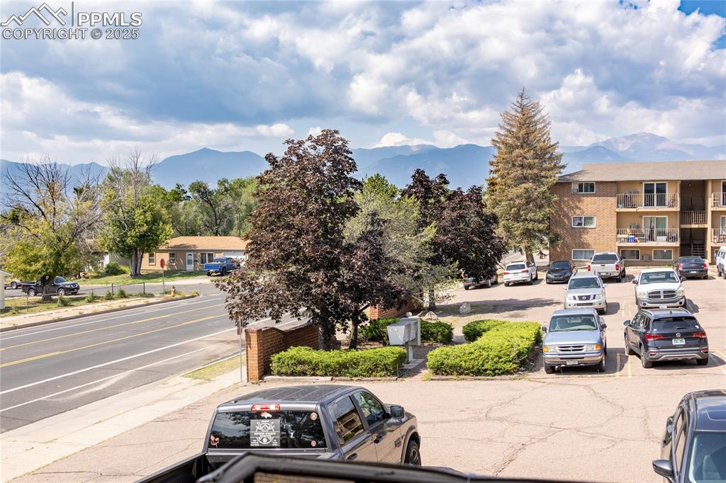 Image 23 of 24: View of asphalt street with a mountain view, sidewalks, and curbs