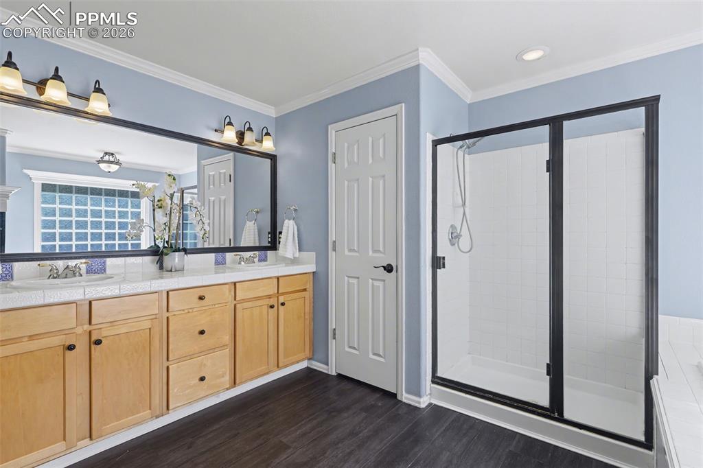 Image 19 of 44: Bathroom with double vanity, dark wood-style flooring, a shower stall, a ba