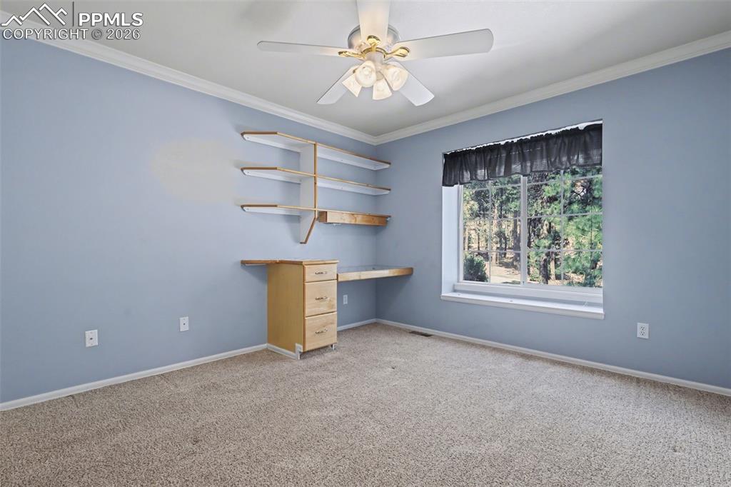 Image 22 of 44: Upstairs Bedroom featuring a ceiling fan, carpet floors, crown molding, and