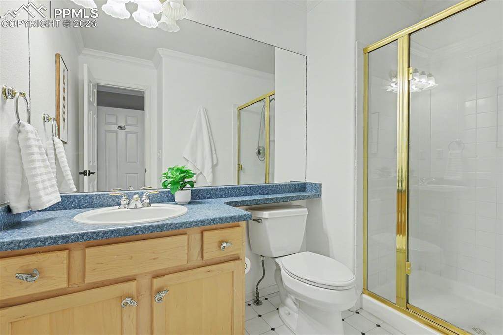 Image 23 of 44: On-Suite Full bath with vanity, a stall shower, and ornamental molding