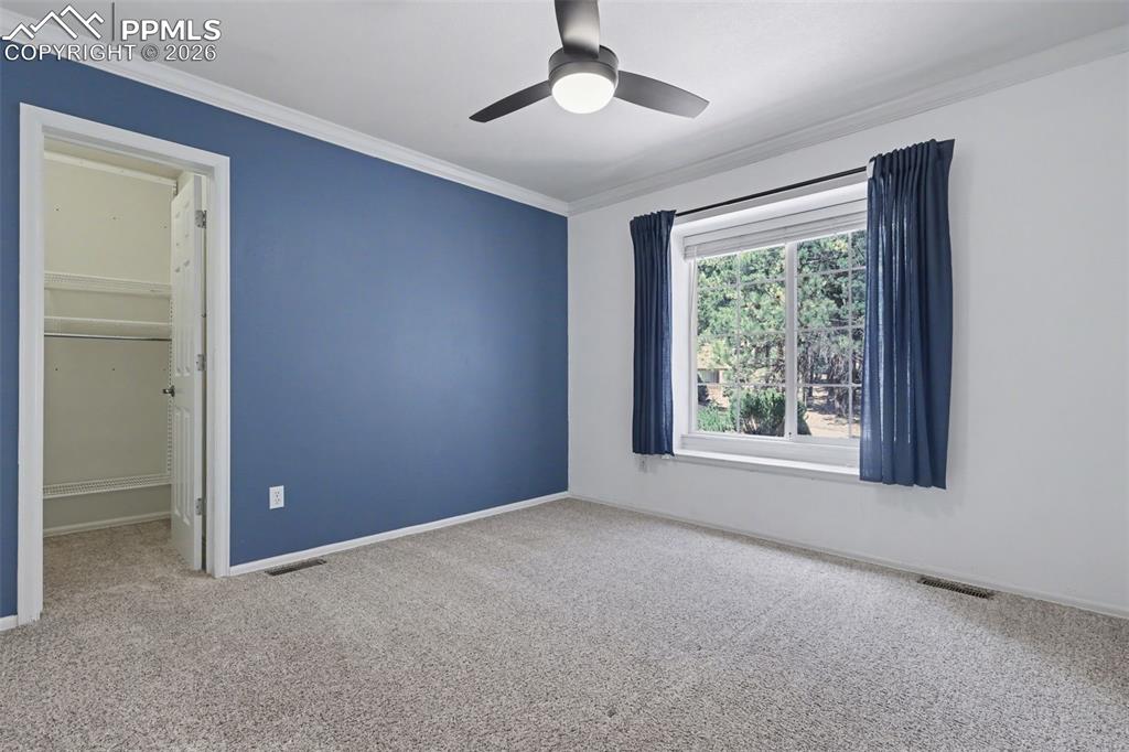 Image 25 of 44: Upstairs bedroom featuring light colored carpet, crown molding, and a ceili