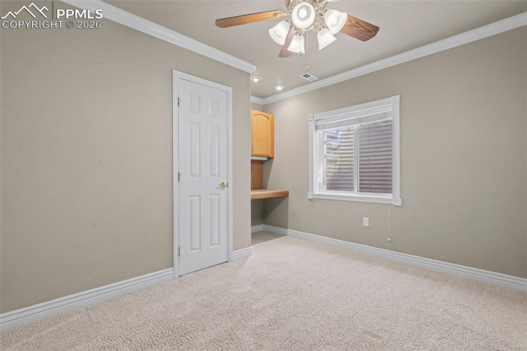Image 34 of 44: Basement bedroom featuring ornamental molding, light colored carpet, and a 