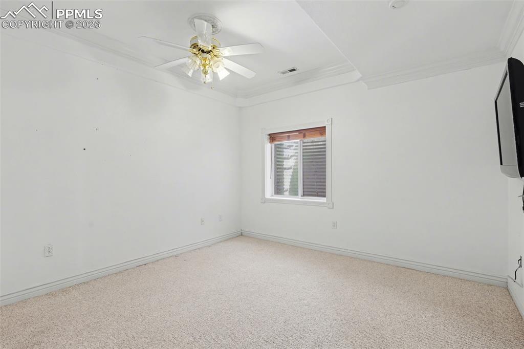 Image 35 of 44: Basement bedroom with ornamental molding, light colored carpet, and a ceili