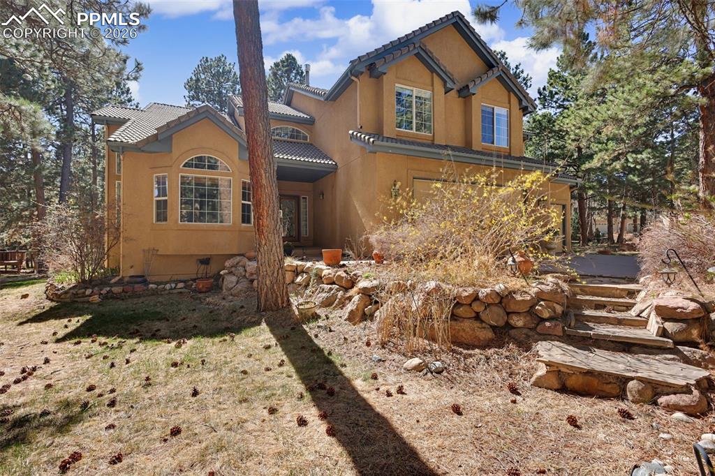 Image 4 of 44: View of front of home featuring a tiled roof and stucco siding