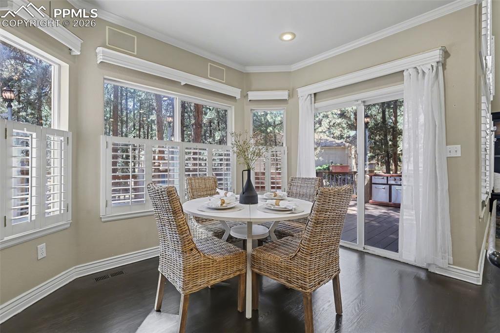 Image 9 of 44: Dining room featuring dark wood-style floors and ornamental molding