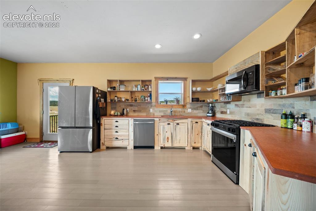 Image 10 of 41: custom Bettkill pine cabinetry and fossil tile accents.