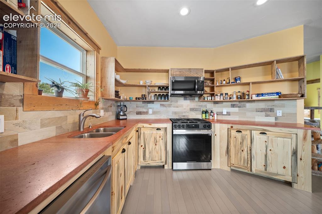 Image 11 of 41: custom Bettkill pine cabinetry and fossil tile accents.