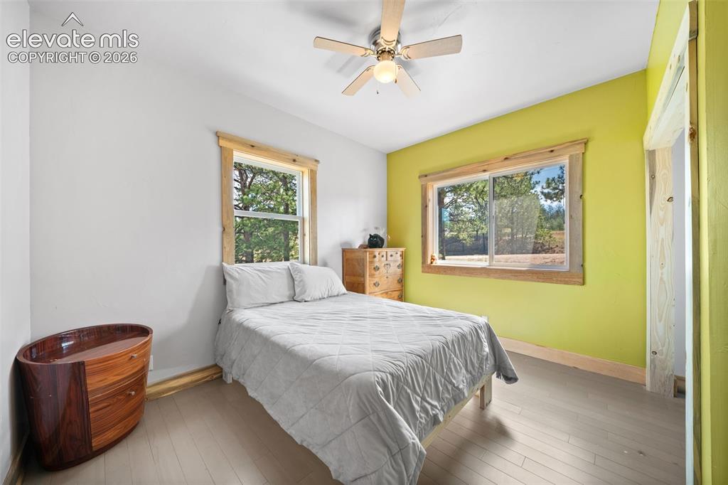 Image 12 of 41: Main-level bedroom with large windows and natural light.