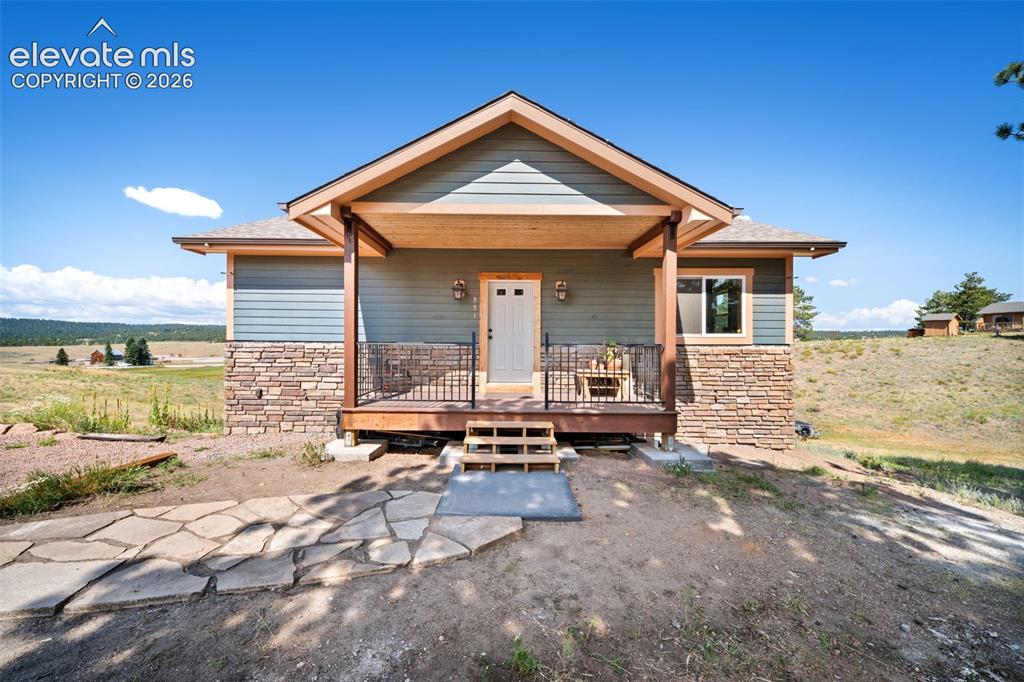 Image 2 of 41: Inviting covered front porch with stone accents.