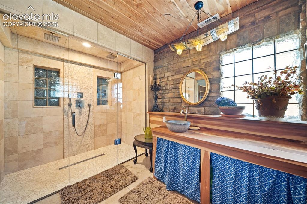 Image 20 of 41: Primary en-suite with a custom tile shower and Delta fixtures.
