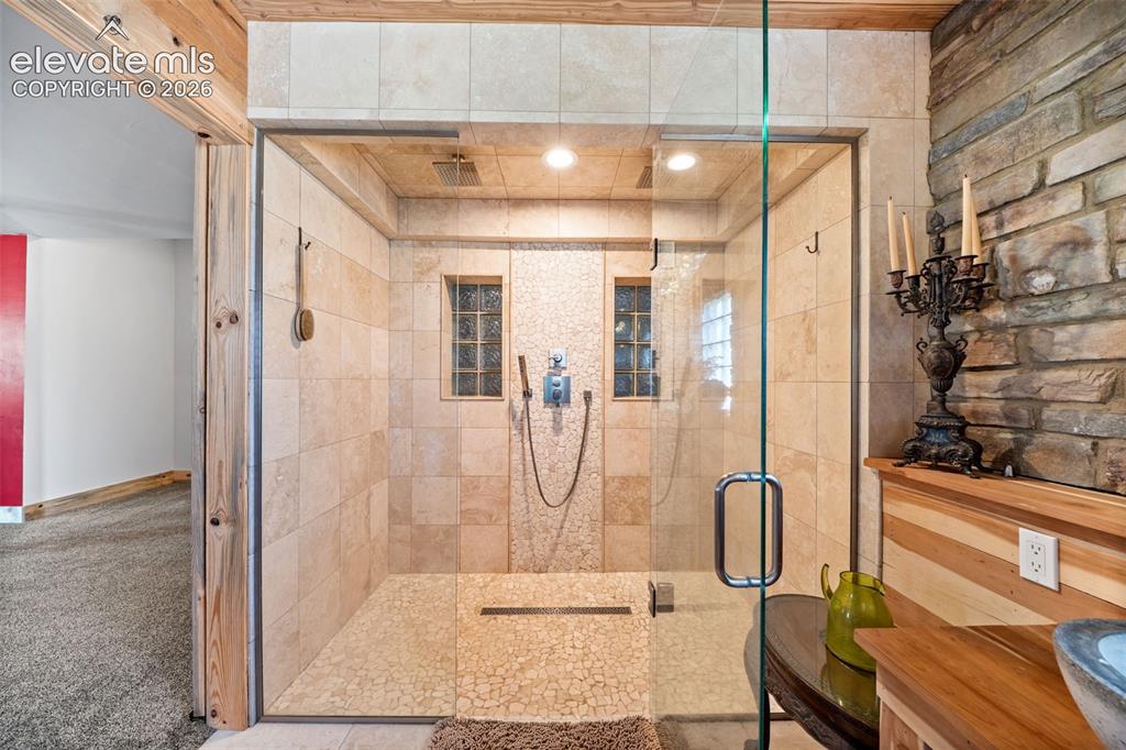 Image 21 of 41: Primary en-suite with a custom tile shower and Delta fixtures.