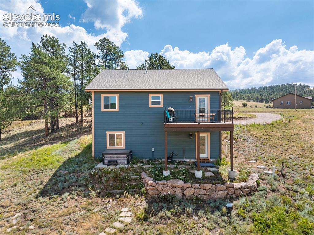 Image 22 of 41: Walkout lower level with an elevated deck and patio below.