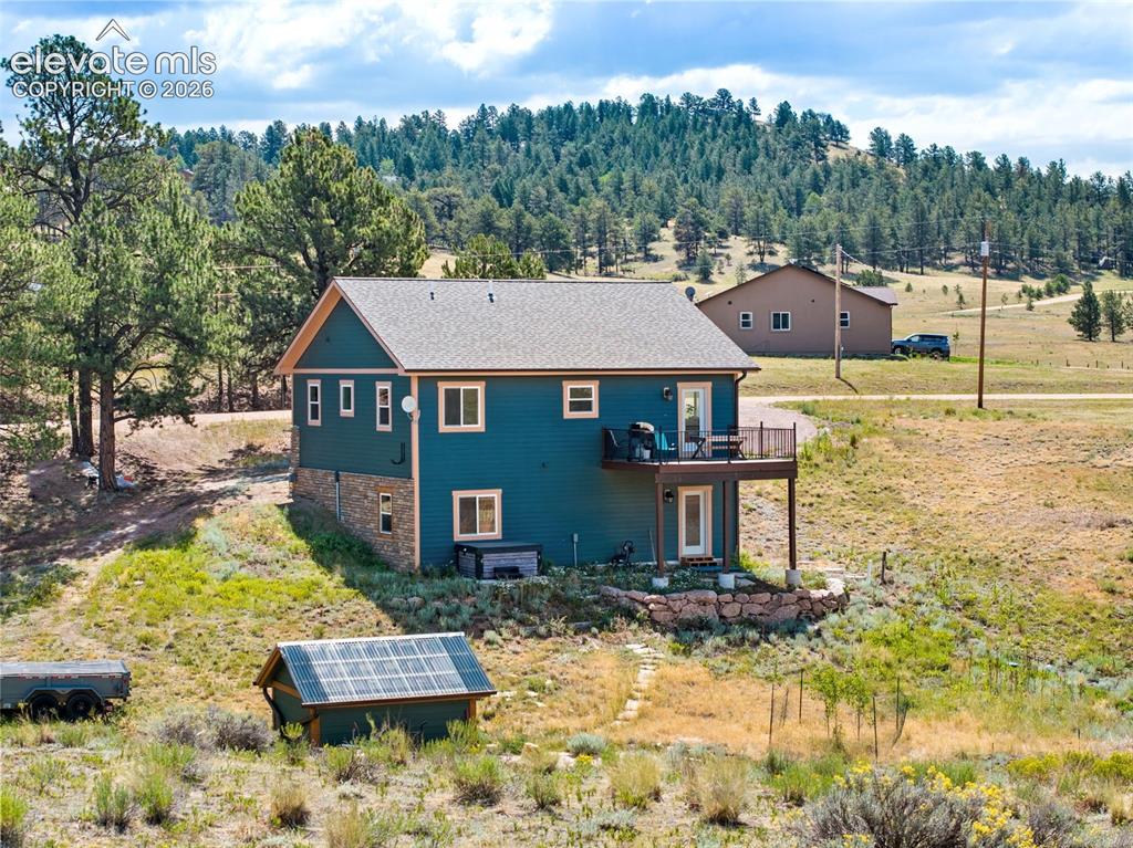 Image 23 of 41: Rear exterior featuring a spacious deck and greenhouse.