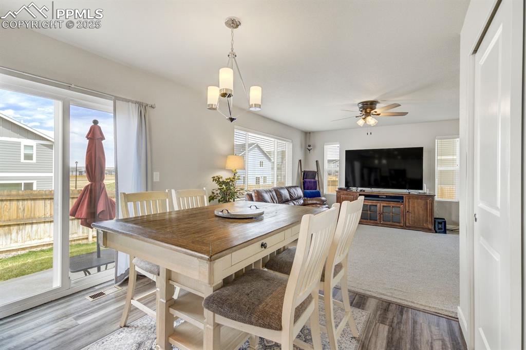 Image 20 of 50: Dining space featuring a ceiling fan, wood finished floors, and visible ven