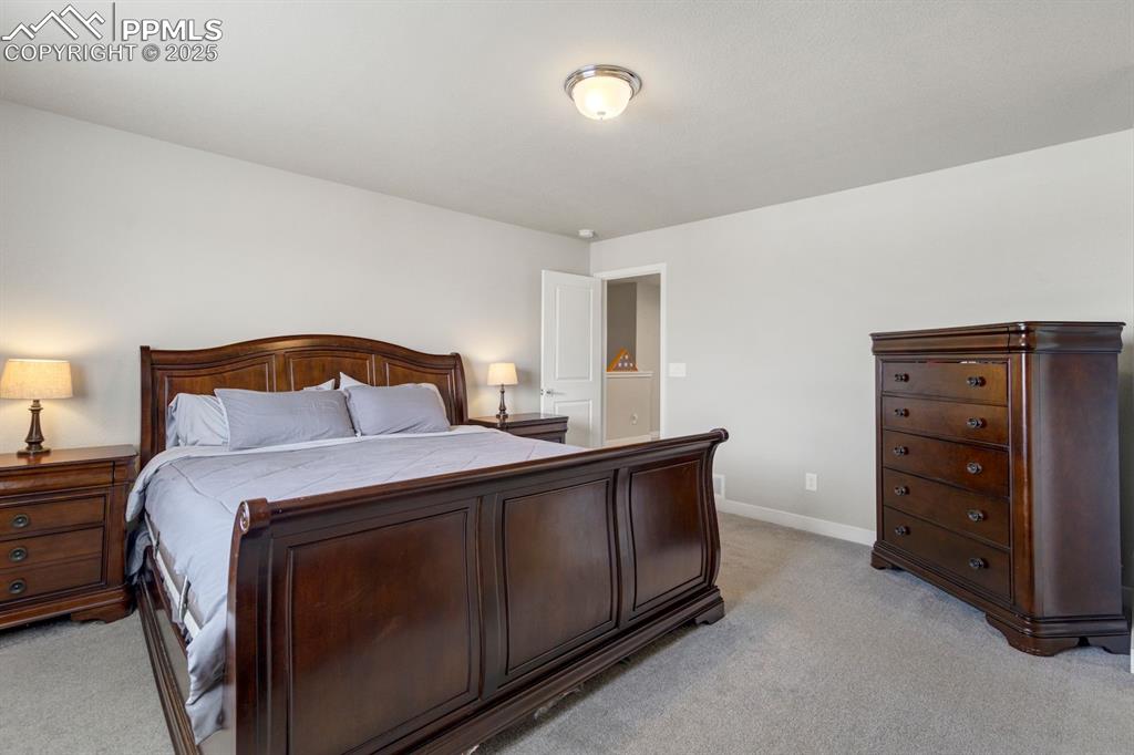 Image 24 of 50: Bedroom with light colored carpet and baseboards