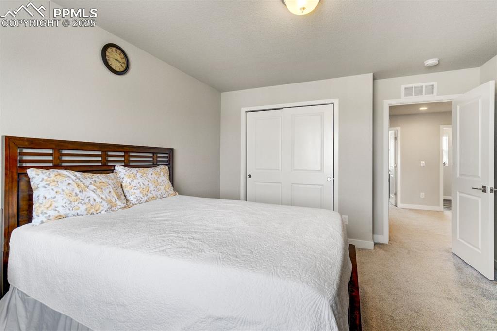 Image 30 of 50: Bedroom with light carpet, a closet, visible vents, and baseboards