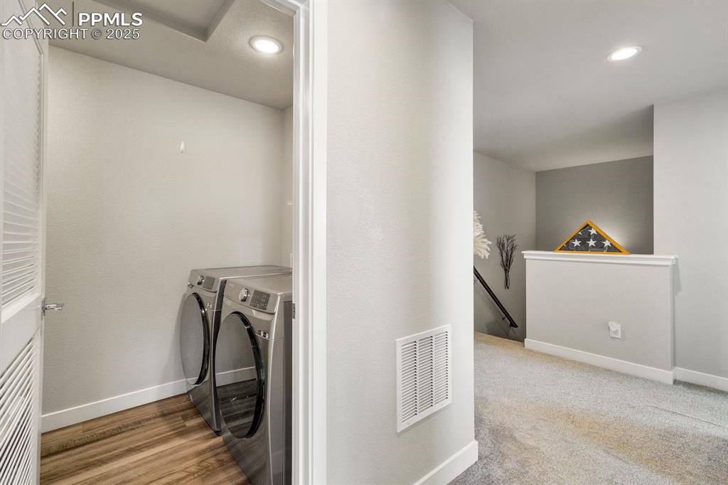 Image 31 of 50: Clothes washing area featuring washing machine and clothes dryer, baseboard