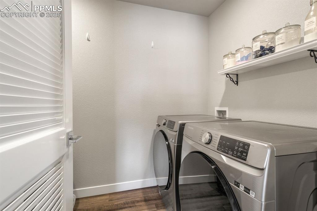 Image 32 of 50: Laundry area with baseboards, dark wood-style floors, independent washer an