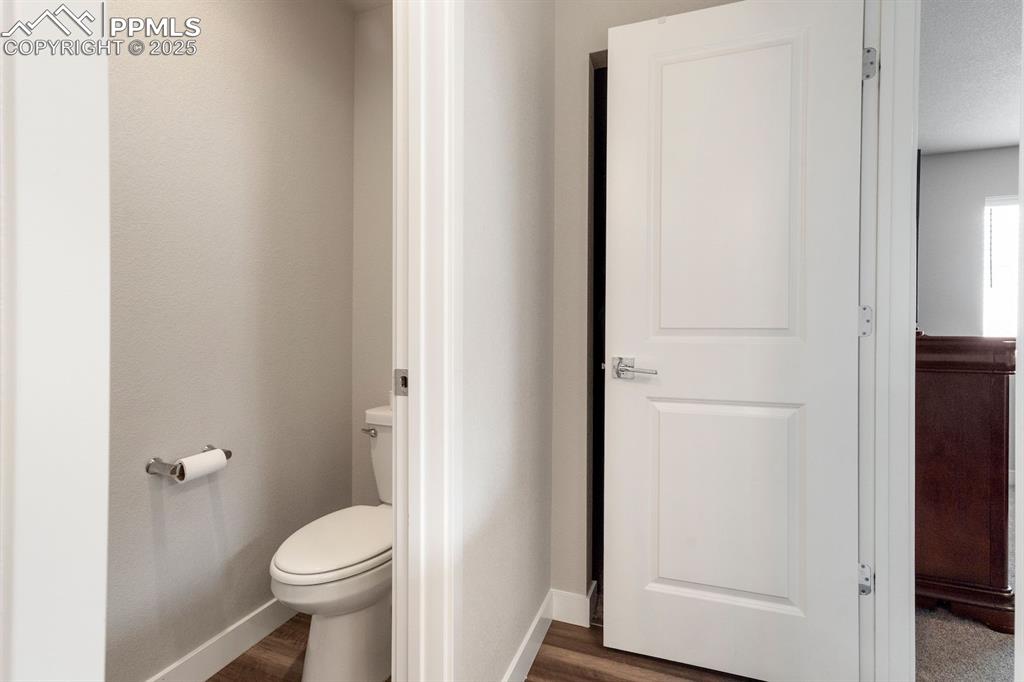 Image 33 of 50: Bathroom featuring baseboards, toilet, and wood finished floors