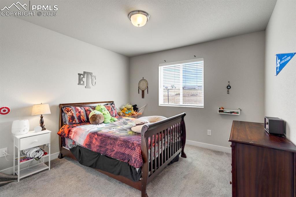 Image 34 of 50: Bedroom featuring light carpet and baseboards