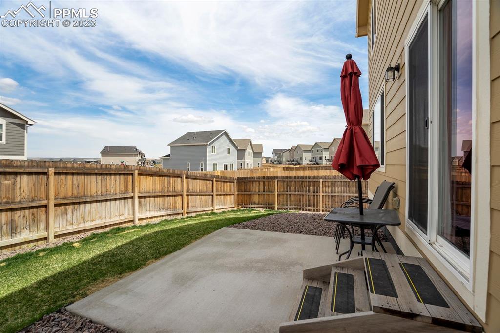 Image 44 of 50: View of patio with a fenced backyard and a residential view