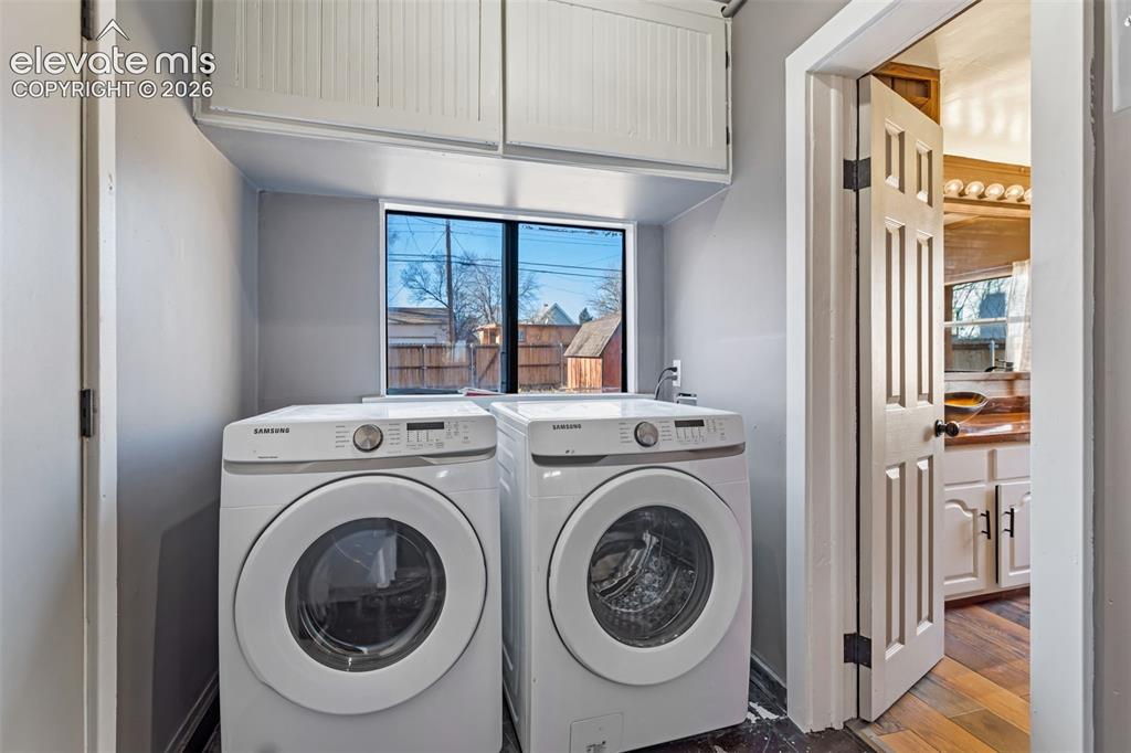 Image 14 of 35: Dedicated laundry area featuring upper white cabinetry, a window, and a uti