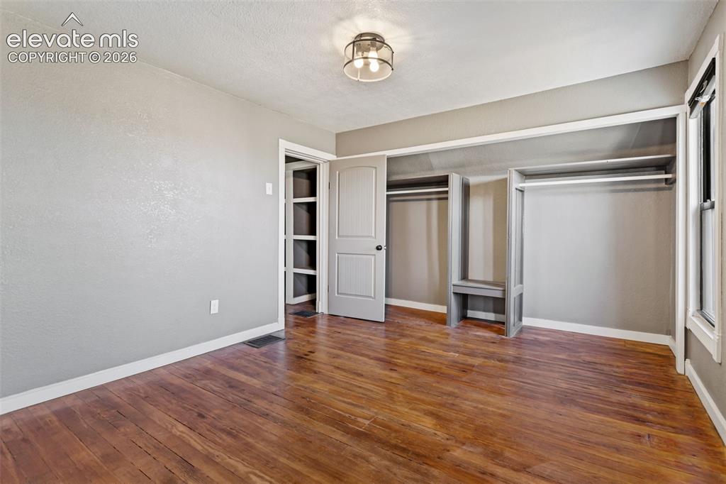 Image 19 of 35: Room featuring wood-finish flooring, neutral wall tones, and white trim