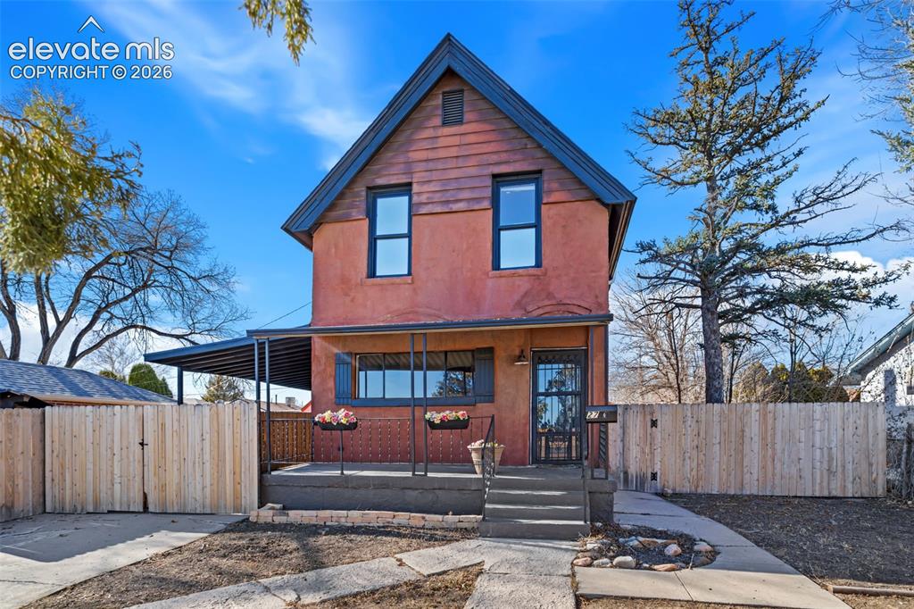 Image 2 of 35: Two-story residence featuring a covered front porch and a gabled roofline