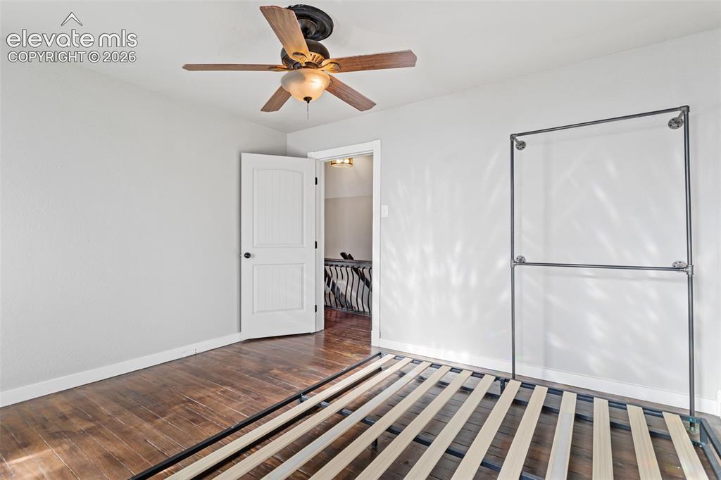 Image 23 of 35: Room featuring wood-finish flooring, white walls, a ceiling fan with light