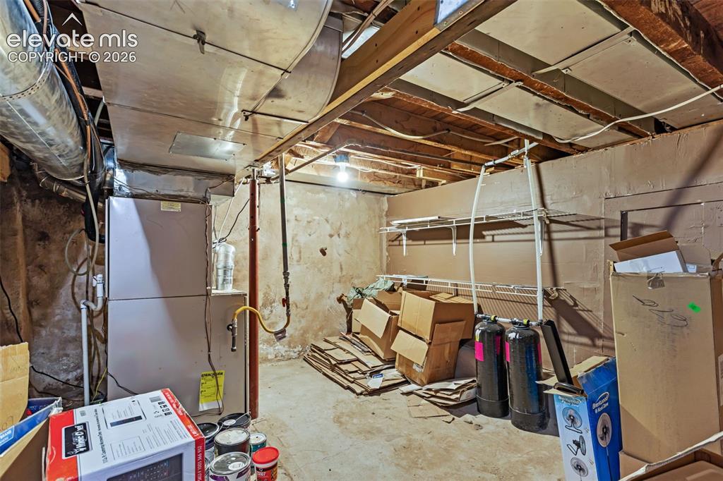 Image 24 of 35: Utility room featuring exposed ceiling joists and concrete flooring