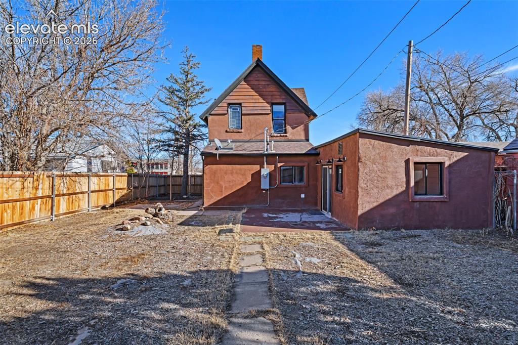 Image 28 of 35: Rear elevation featuring a stucco finish, a private patio area, and a wood