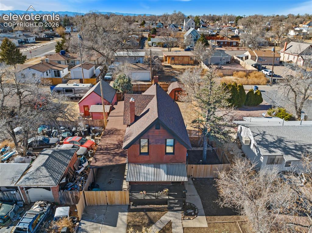 Image 31 of 35: Brick-clad residence with a pitched roof and a covered front porch