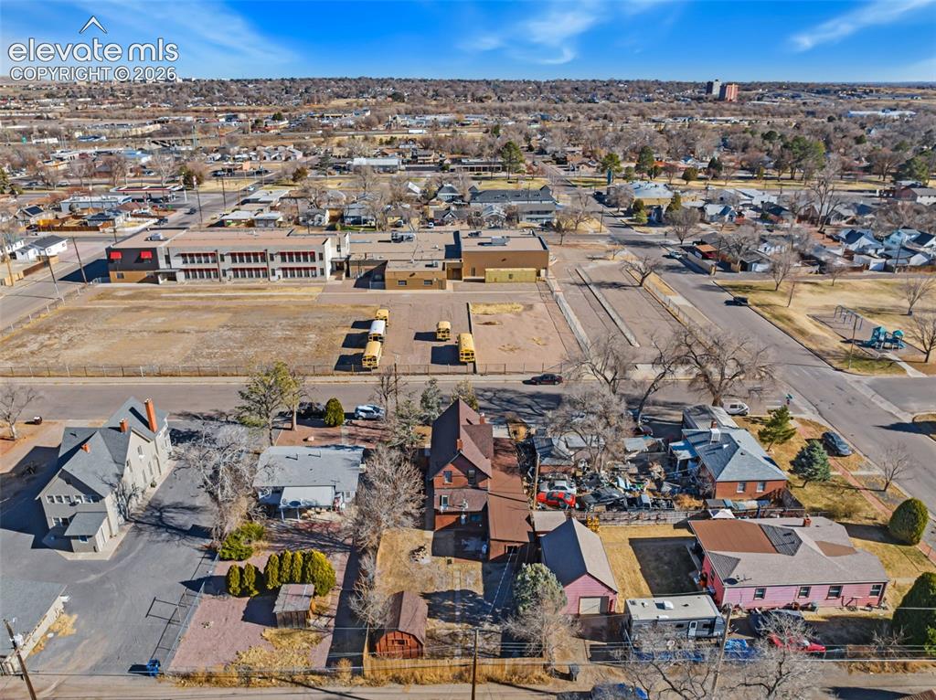 Image 32 of 35: Aerial perspective showcasing multiple residential properties and a commerc