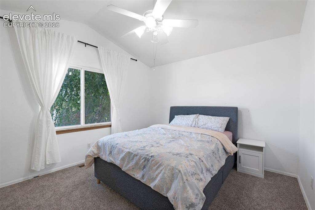Image 15 of 31: Interior room with vaulted ceiling and a ceiling fan light fixture