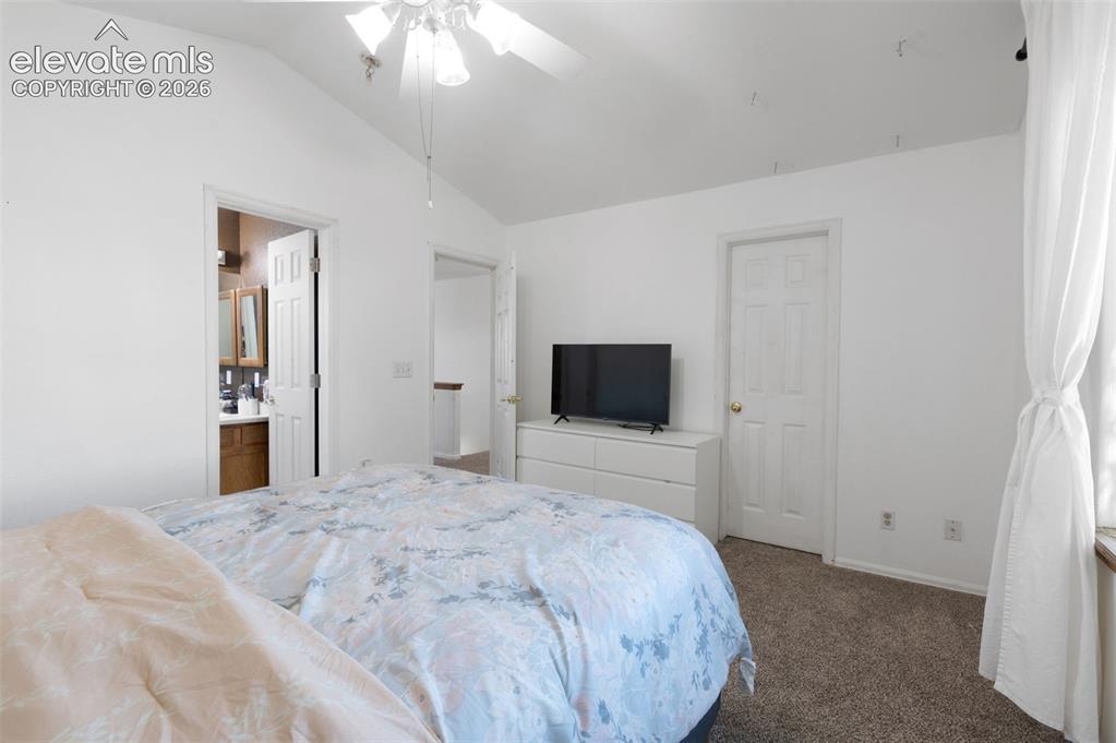 Image 17 of 31: Bedroom featuring vaulted ceilings, ceiling fan, neutral wall paint, and ca
