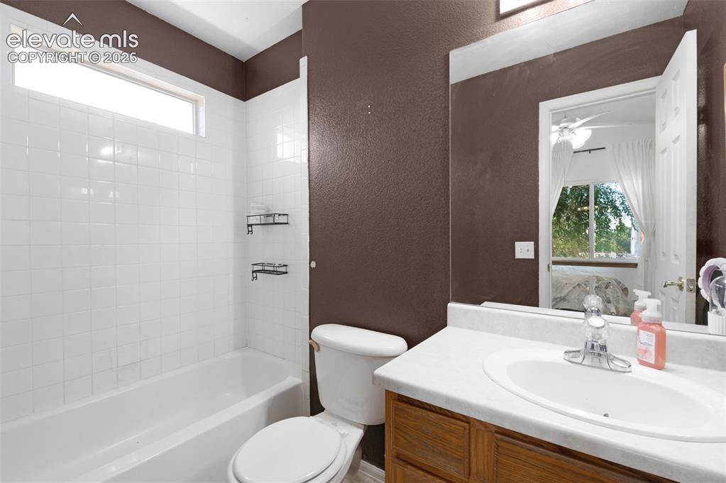 Image 19 of 31: Bathroom featuring a white subway tile tub surround with a transom window
