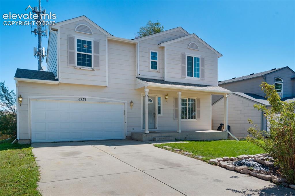 Image 2 of 31: Two-story residence featuring a covered front porch, attached two-car garag