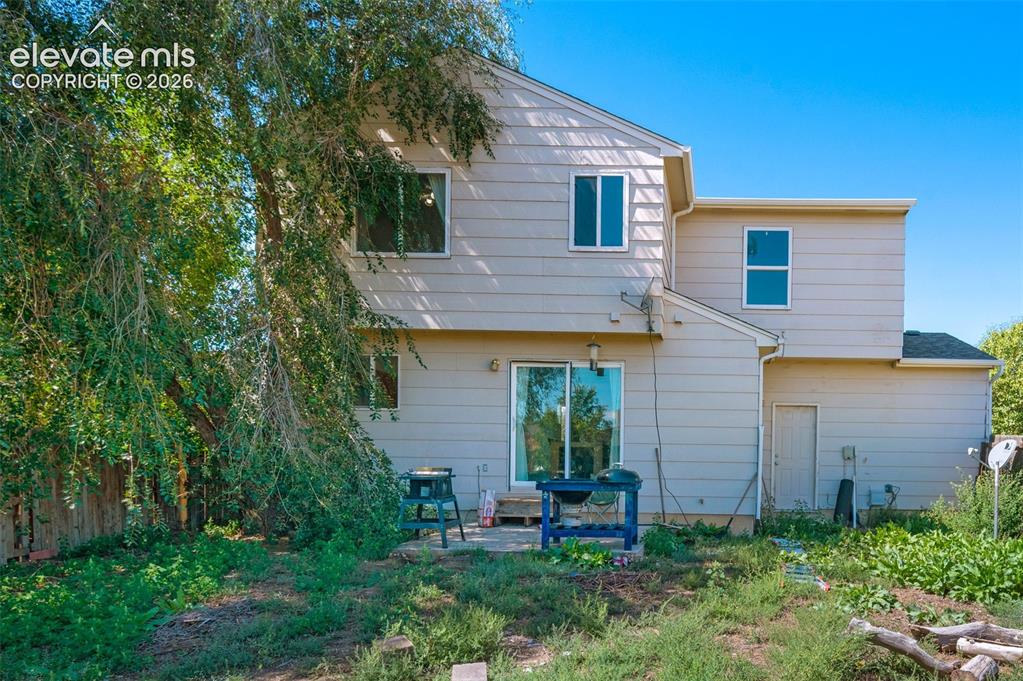 Image 30 of 31: Rear exterior featuring a sliding glass door, a ground-level door, and mult
