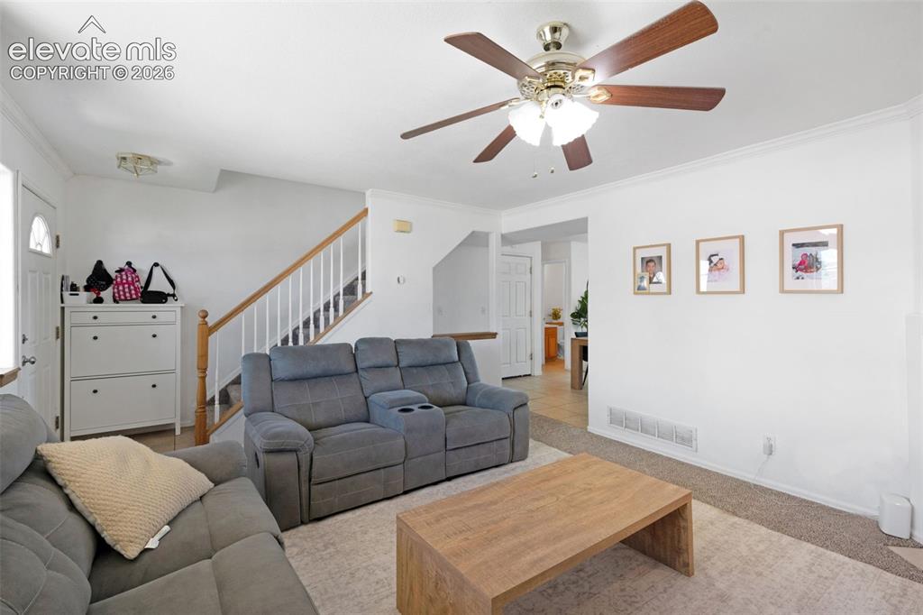 Image 8 of 31: Living area featuring light-toned carpeting and white wall finishes