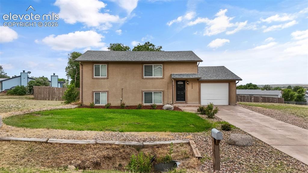 Image 1 of 43: Two-story stucco residence with an attached garage, featuring a gravel and 
