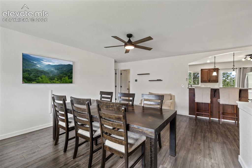 Image 10 of 43: Open-concept dining area featuring wood-finish flooring, a ceiling fan with