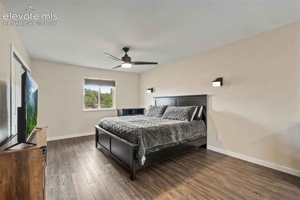 Image 16 of 43: Spacious room featuring wood-finish flooring, a contemporary ceiling fan, a