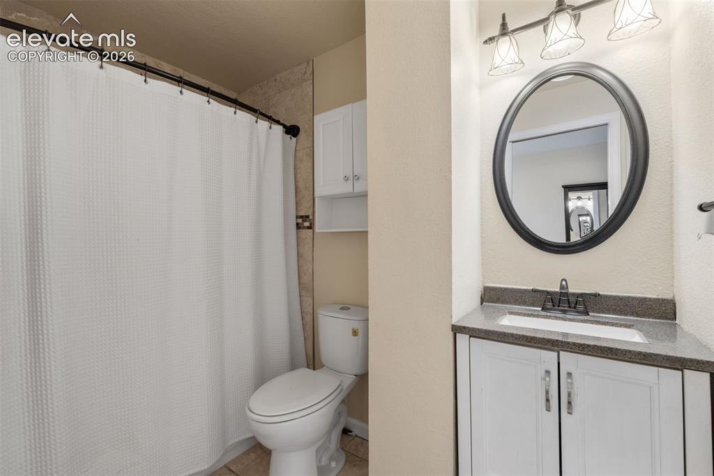Image 19 of 43: Bathroom vanity with a dark countertop and undermount sink