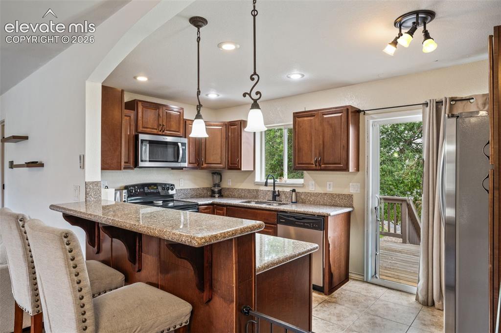 Image 2 of 43: Kitchen featuring wood cabinetry, granite countertops, stainless steel appl