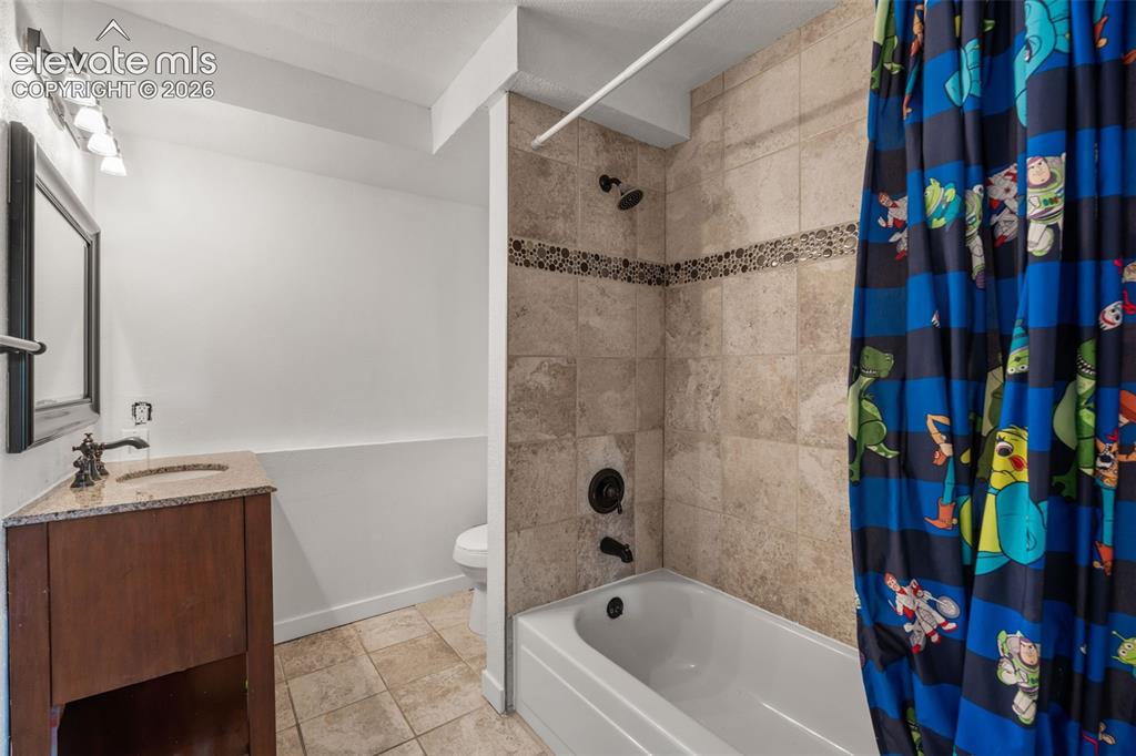 Image 26 of 43: Bathroom featuring a full tub/shower combination with tile surround and dec